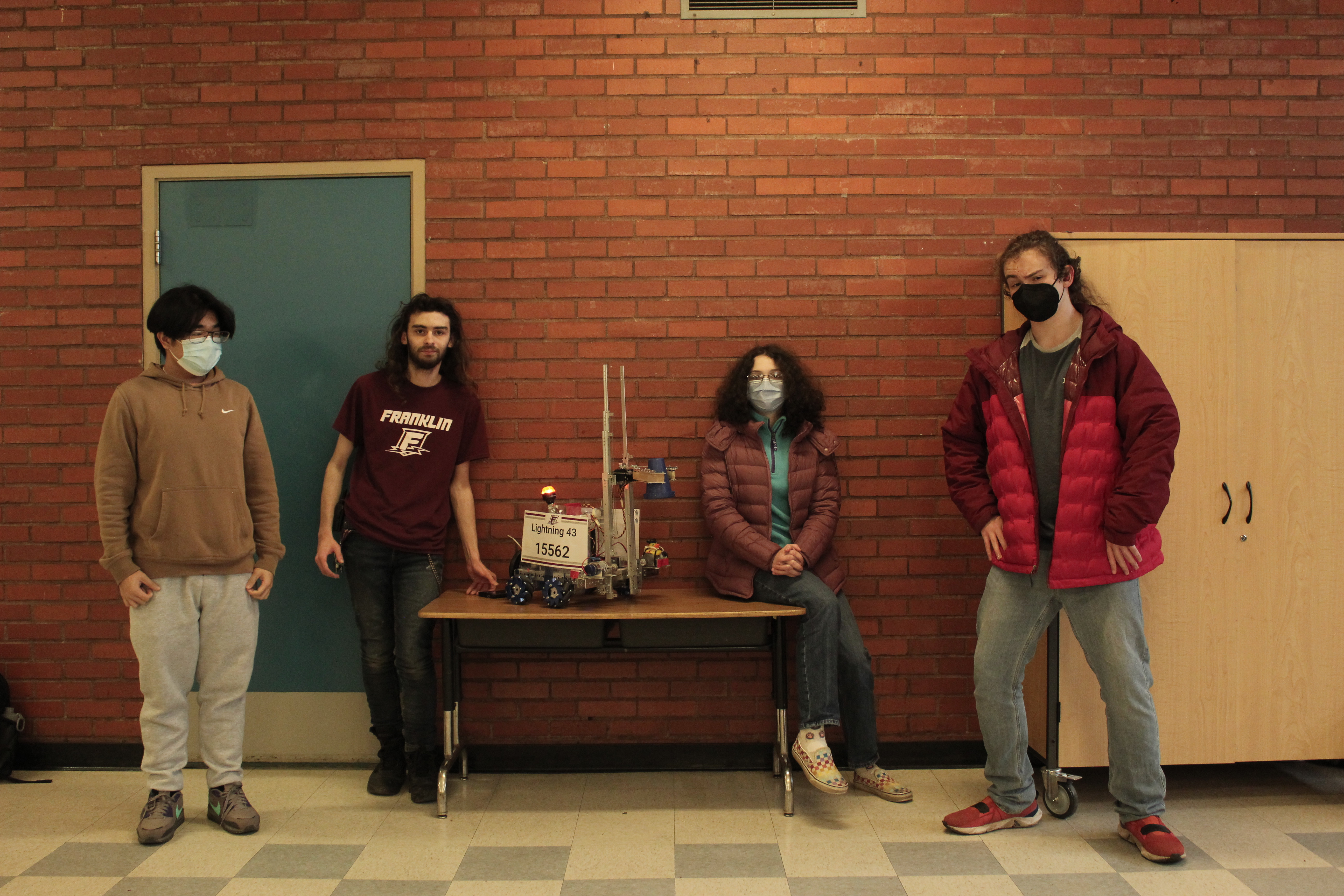 4 students standing with their robot